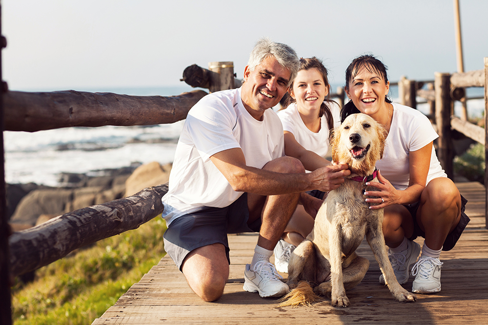 sporty family and their pet dog at the beach in the morning